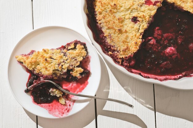 pedaço de torta tradicional de frutas britânicas, bolo de cranberry e framboesa em um prato e em uma assadeira, tiro de estilo de vida