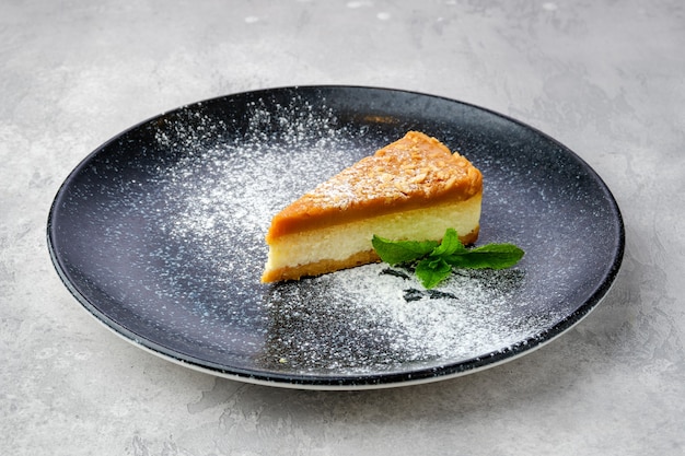 Pedaço triangular de bolo de queijo caramelo em um prato