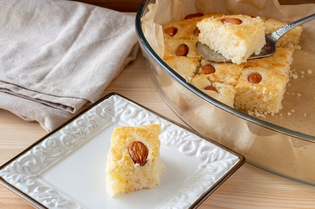 Pedaços Basbousa ou Namoora tradicional sobremesa doce árabe com amêndoa. Bolo de semolina caseiro. Foco seletivo.