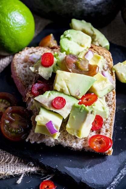 Pedaços de abacate, cebola, pimenta e suco de limão na torrada