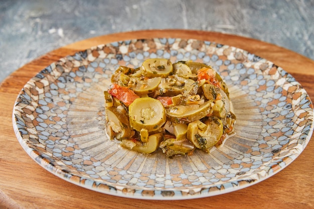 Pedaços de abobrinha com tomate no prato fundo de madeira