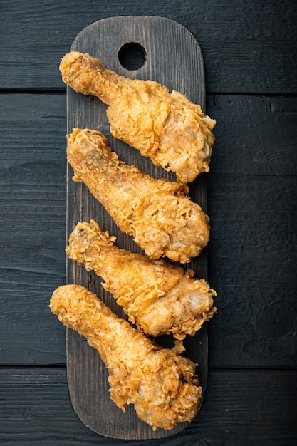 Pedaços de baqueta de frango à milanesa na mesa de madeira preta