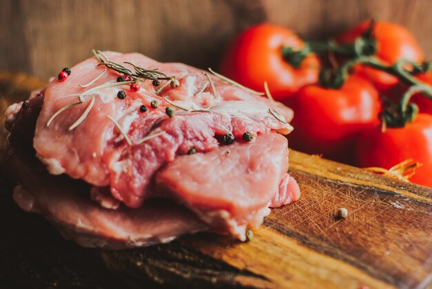 Pedaços de bife de carne de porco crua com especiarias e ervas Alecrim, tomilho, manjericão, sal e pimenta