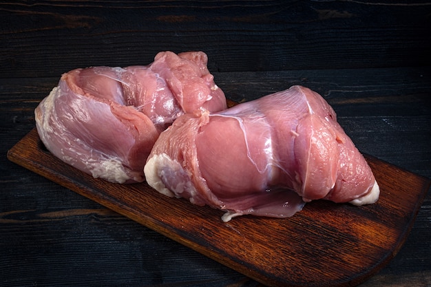 Pedaços de carne crua no prato na mesa de madeira