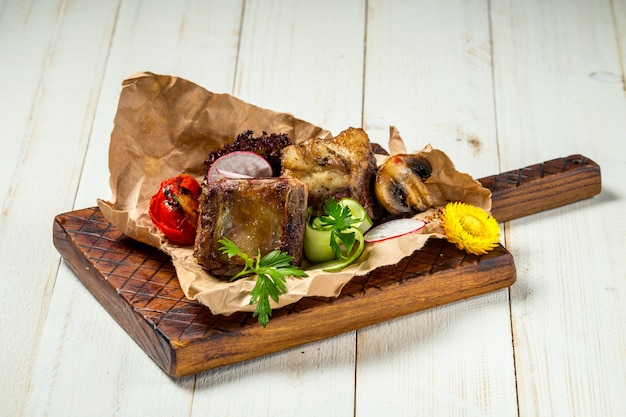 Pedaços de carne de bovino grelhado assado na placa de madeira