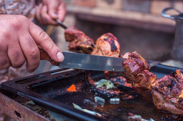 pedaços de carne de porco amarrados em um espeto na grelha cozinhando um churrasco em férias