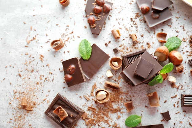 Pedaços de chocolate com avelãs e hortelã fresca na luz de fundo