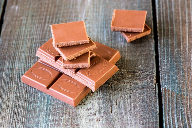 Pedaços de chocolate em um fundo de madeira