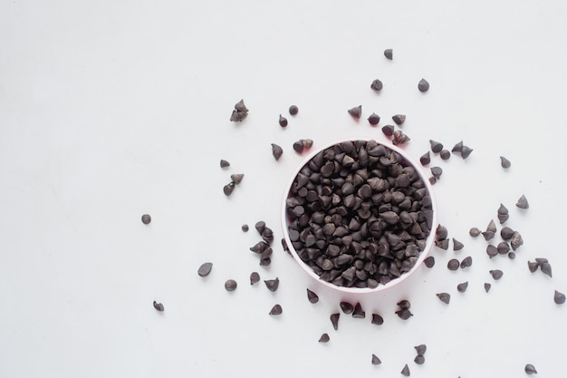 Pedaços de chocolate em um recipiente no fundo branco