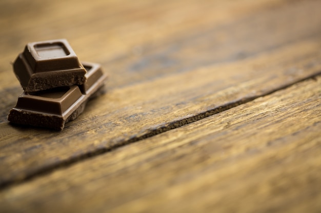 Pedaços de chocolate em uma mesa de madeira