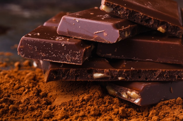 Pedaços de chocolate escuros naturais na mesa de madeira