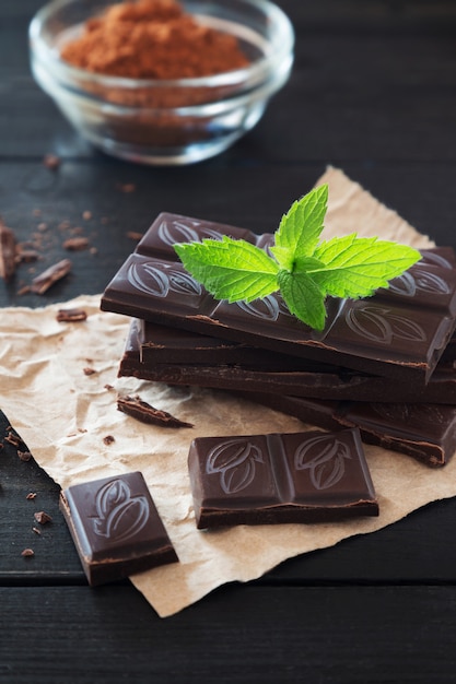 Pedaços de chocolate no fundo de madeira preto