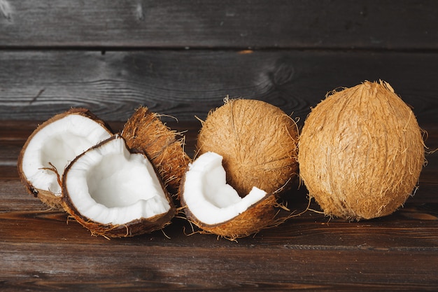 Pedaços de coco rachado na superfície de madeira escura