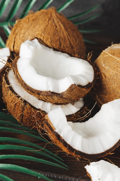 Pedaços de coco rachado no escuro de madeira