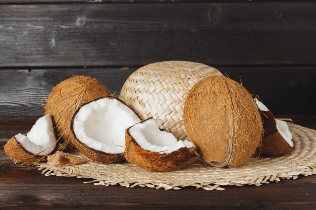 Pedaços de coco rachados no fundo escuro de madeira