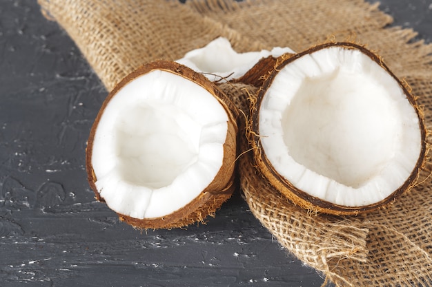 Pedaços de coco rachados no fundo escuro de madeira