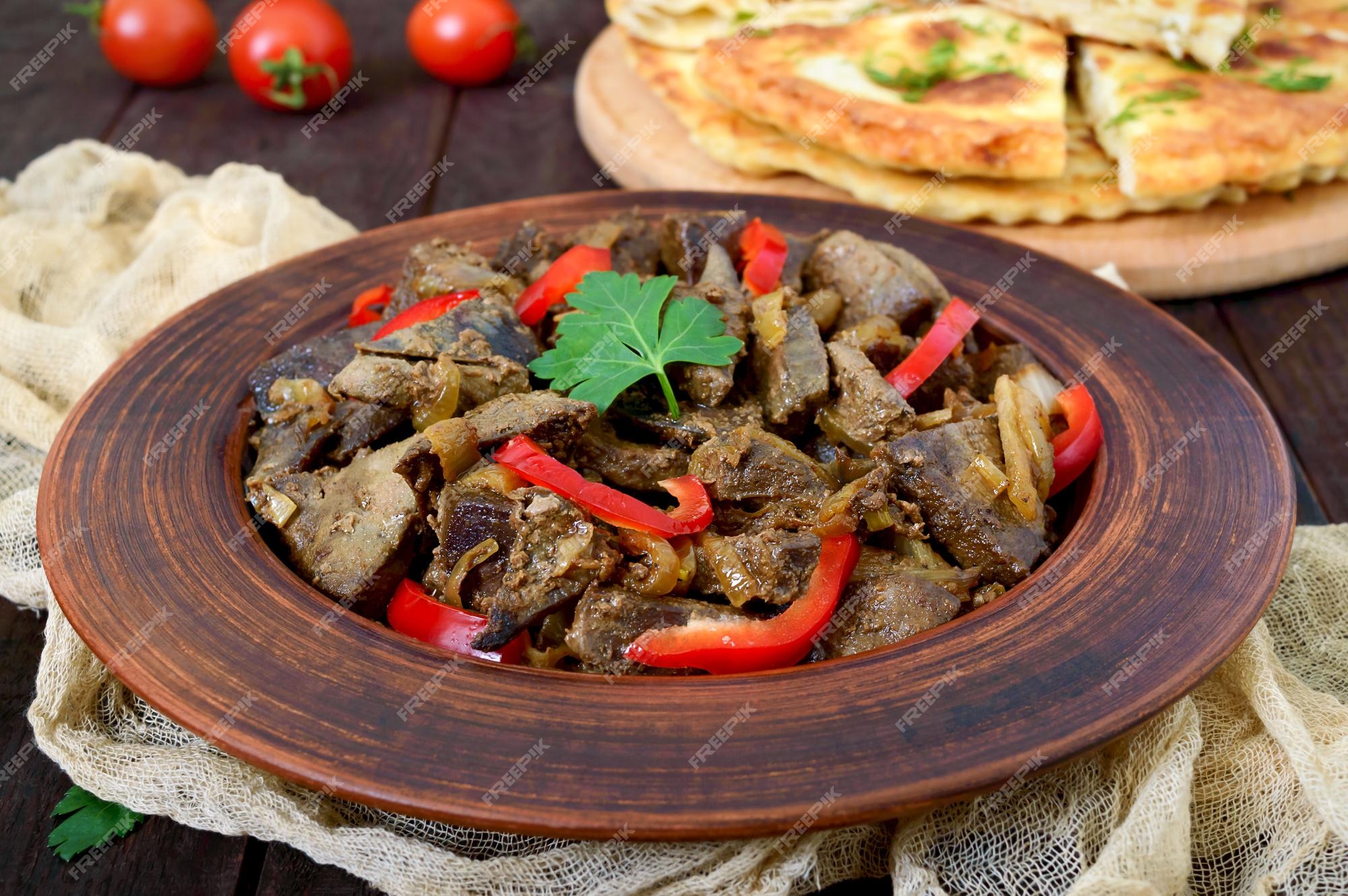 Pedaços de fígado frito com cebola e pimentão fresco em um prato. delicioso  prato saudável.