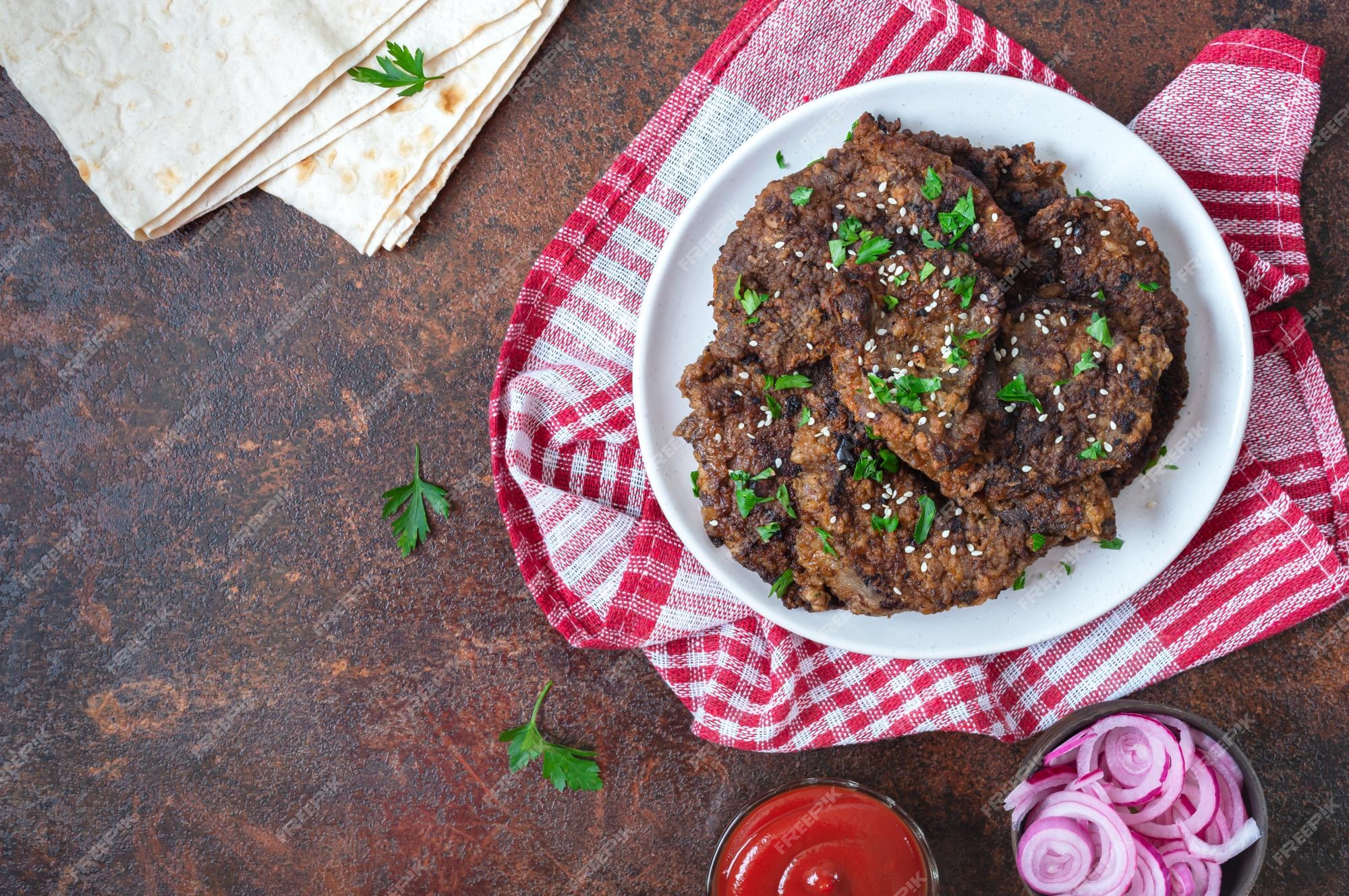 Pedaços de fígado frito com molho de tomate, cebolas e pepinos em conserva  delicioso prato saudável vista superior