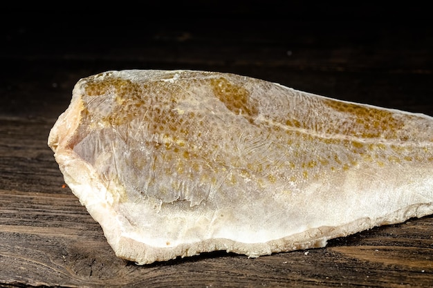 pedaços de filé de peixe vermelho e branco em um pacote congelado em um plástico de papelão, aberto, em uma madeira escura