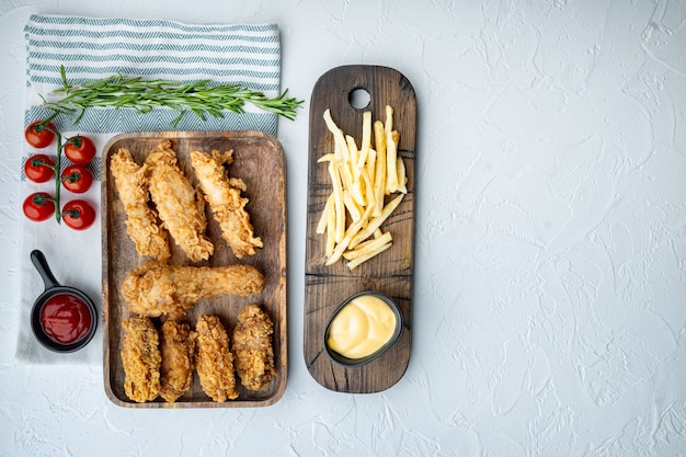 Pedaços de frango frito crocante com batatas fritas no fundo branco