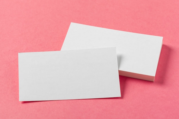 Pedaços de papel em branco em uma superfície rosa colorida