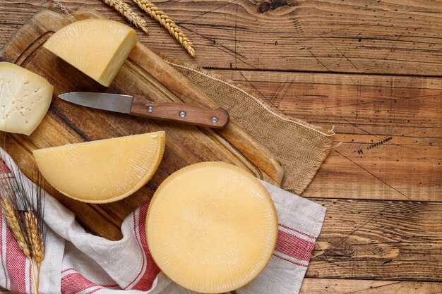 Pedaços de queijo caseiro fresco em uma placa de madeira vista de cima