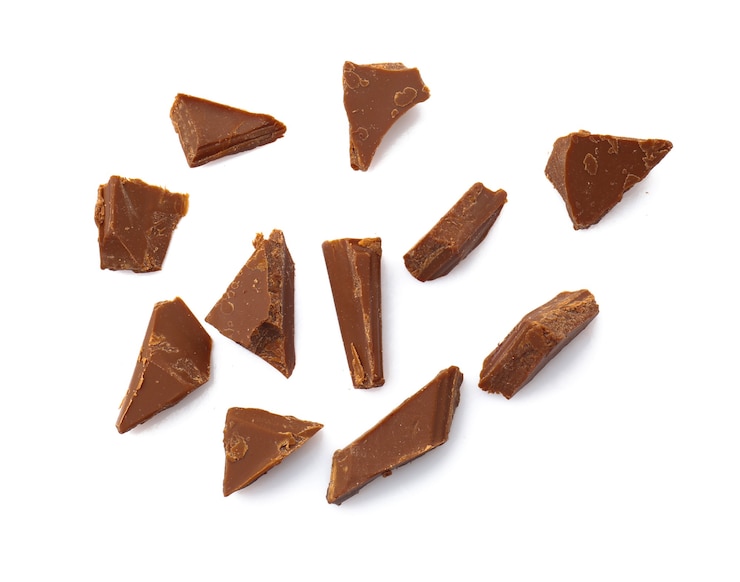 Foto pedaços de saboroso chocolate ao leite em fundo branco