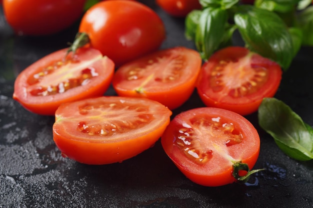 Pedaços de tomates frescos cortados sobre fundo escuro