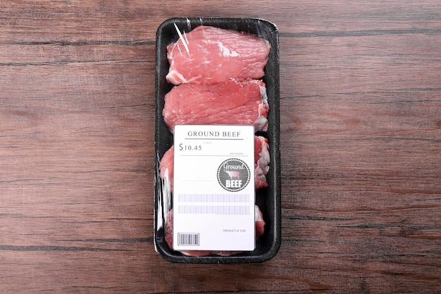 Pedaços embalados de carne bovina em fundo de madeira