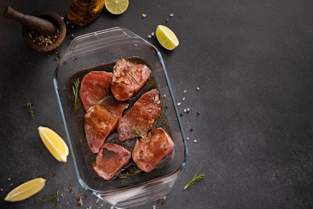 Pedaços marinados de filé de atum fresco em um prato de vidro em uma mesa de cozinha