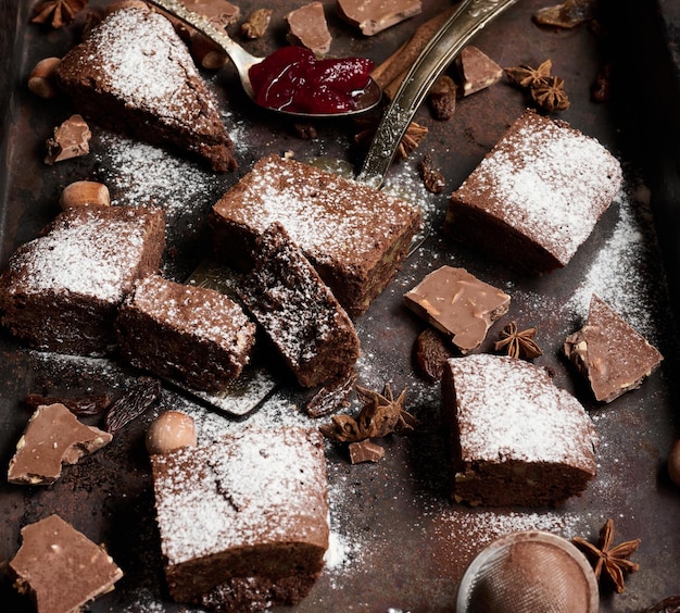 Pedaços quadrados assados de brownie de chocolate polvilhados com açúcar de confeiteiro