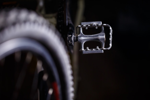 Pedal de metal preto em uma bicicleta com luz forte. Acessórios de bicicleta