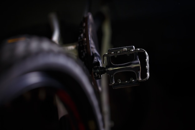 Pedal de metal preto em uma bicicleta com luz forte. Acessórios de bicicleta