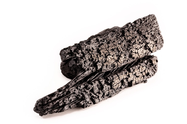 Pedazo de carbón vegetal, combustible ardiente, superficie blanca aislada