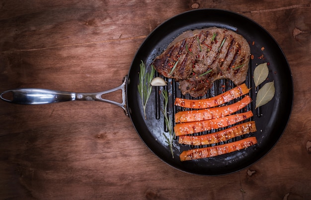 Pedazo de carne frita en una sartén redonda