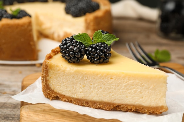 Pedazo de delicioso pastel de queso decorado con moras en la mesa