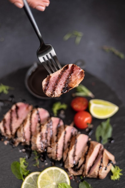 Foto un pedazo de filete de atún cocido a la parrilla en una tabla de piedra negra