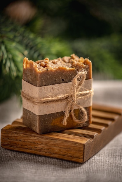 Un pedazo de jabón natural hecho a mano en un plato de jabón de madera y un mantel de lino