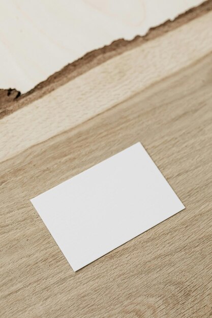 Foto un pedazo de papel en una mesa de madera con una tarjeta blanca en ella