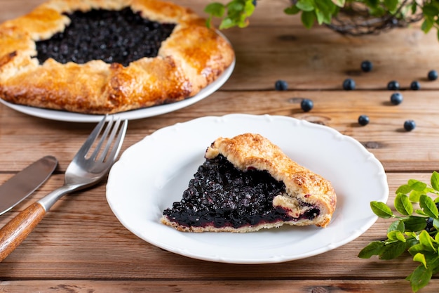 Pedazo de pastel de arándanos en un plato sobre una mesa de madera