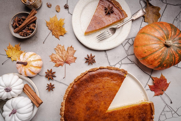 Pedazo de pastel de calabaza americano con canela en la vista superior de fondo de hormigón gris