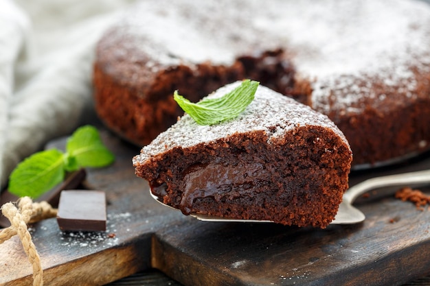 Pedazo de pastel de chocolate espolvoreado con azúcar en polvo