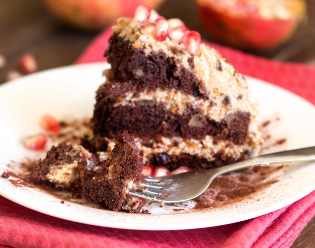 Pedazo de pastel de chocolate, nuez y ciruela en un plato de cerca