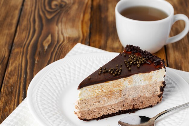 Pedazo de pastel de chocolate en un plato blanco sobre la mesa