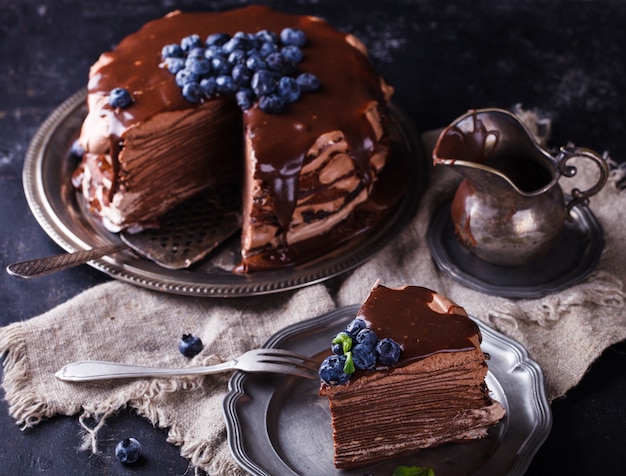 Pedazo de pastel de chocolate con tortitas de chocolate y glaseado.