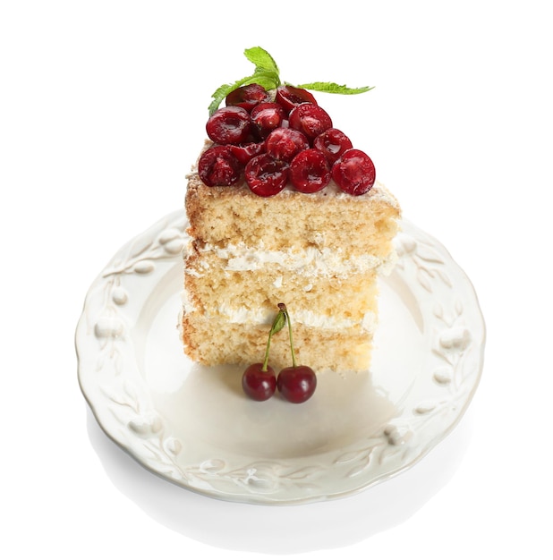Pedazo de pastel decorado con cerezas sobre fondo blanco.