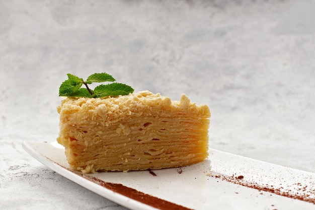 Pedazo de pastel de Napoleón con menta en un plato