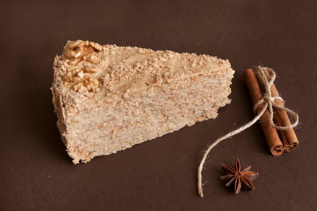 Pedazo de pastel con nueces con palitos de canela y especias de anís estrellado