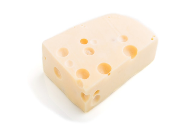 Pedazo de queso amarillo aislado sobre superficie blanca