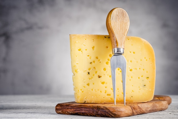 Foto pedazo de queso de cerveza ammergauer sobre una mesa de madera clara